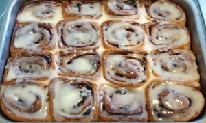 Rotolini alla cannella appena sfornati, ricoperti di glassa bianca e lucida, pronti per essere gustati.