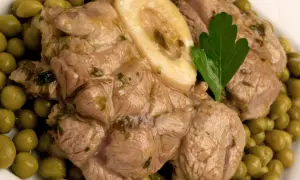 Ossobuco con piselli, un piatto succulento con carne tenera e piselli verdi brillanti, guarnito con una foglia di prezzemolo.