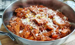 Trippa alla fiorentina fumante in un tegame, cosparsa di parmigiano grattugiato e scorza di limone. Un classico della cucina toscana.