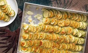Fette di zucchine gratinate in teglia, un contorno di verdure dorato e invitante, pronto per essere gustato.