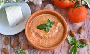 Pesto alla siciliana in ciotola di terracotta, con pomodori, mandorle, basilico e ricotta fresca.