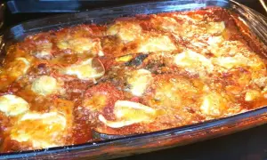 Parmigiana di melanzane non fritte appena sfornata, dorata e filante, pronta per essere gustata.