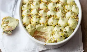 Delizioso tiramisù senza caffè, con crema al pistacchio e biscotti savoiardi, guarnito con granella di pistacchi.