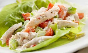 Insalata di pollo con maionese, pomodoro e sedano, servita su foglie di lattuga croccante. Una ricetta fresca e gustosa.