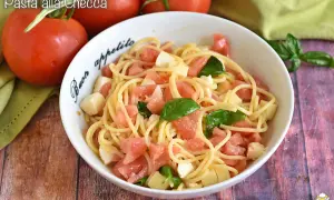 Pasta alla checca con pomodori freschi, mozzarella e basilico, un piatto estivo semplice e gustoso.