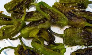 Friggitelli arrostiti con sale grosso, pronti per essere gustati. Ecco come cucinare i friggitelli per un contorno saporito.