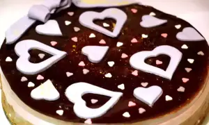 Deliziosa bavarese al cioccolato decorata con cuori lilla, cuoricini colorati e un fiocco.