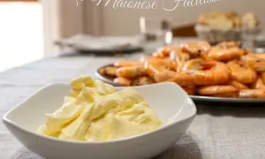 Maionese cremosa fatta in casa con minipimer, pronta per accompagnare un piatto di gamberi freschi.