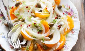 Deliziosa insalata finocchi e arance, con olive verdi e pepe rosa, guarnita con finocchietto fresco. Un piatto fresco e colorato.