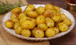 Un piatto invitante di patate novelle al forno, dorate e condite con erbe aromatiche, pronte per essere gustate.