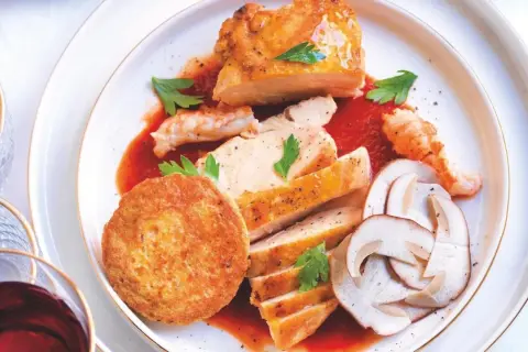 Piatto di pollo alla marengo con gamberi, funghi e tortino.