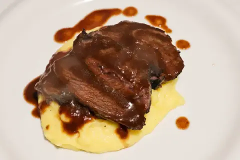 Guancia di vitello tenerissima su un letto di purè, nappata con una ricca salsa bruna.
