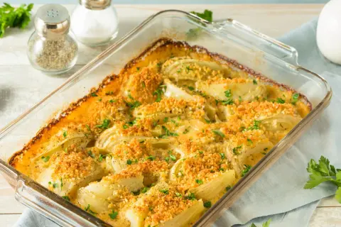 Finoçchi gratinati al forno, dorati e croccanti, con prezzemolo fresco. Un piatto invitante e saporito.