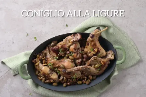 Un saporito coniglio alla ligure, cotto in tegame con olive, pinoli e erbe aromatiche, pronto per essere gustato.