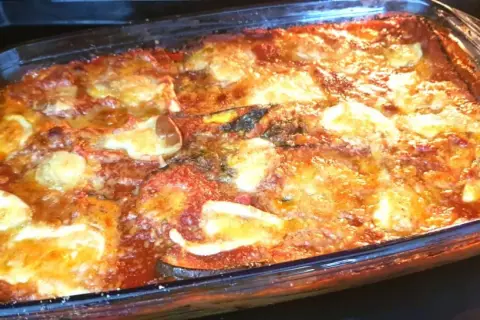Parmigiana di melanzane non fritte appena sfornata, dorata e filante, pronta per essere gustata.