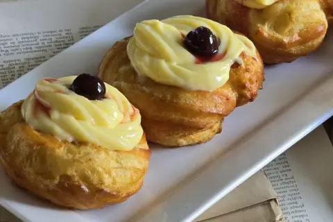 Zeppole di San Giuseppe: dolci fritti con crema pasticcera e ciliegina, un'esplosione di sapore.