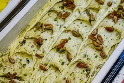 Gelato cremoso al pesto di pistacchio, guarnito con pistacchi interi tostati.