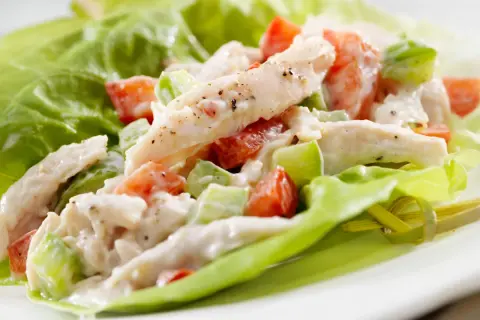 Insalata di pollo con maionese, pomodoro e sedano, servita su foglie di lattuga croccante. Una ricetta fresca e gustosa.