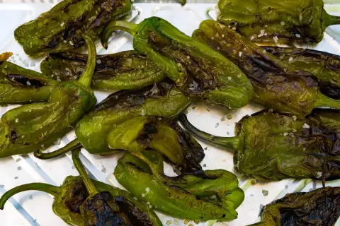 Friggitelli arrostiti con sale grosso, pronti per essere gustati. Ecco come cucinare i friggitelli per un contorno saporito.