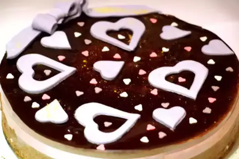 Deliziosa bavarese al cioccolato decorata con cuori lilla, cuoricini colorati e un fiocco.