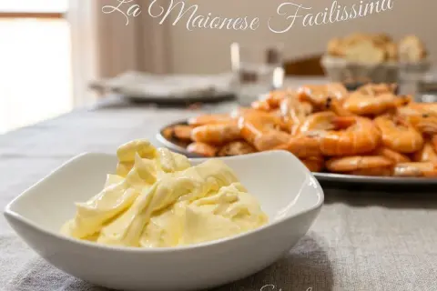 Maionese cremosa fatta in casa con minipimer, pronta per accompagnare un piatto di gamberi freschi.