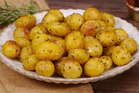 Un piatto invitante di patate novelle al forno, dorate e condite con erbe aromatiche, pronte per essere gustate.