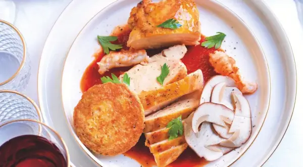 Piatto di pollo alla marengo con gamberi, funghi e tortino.