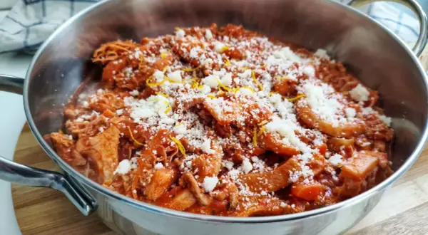 Trippa alla fiorentina fumante in un tegame, cosparsa di parmigiano grattugiato e scorza di limone. Un classico della cucina toscana.