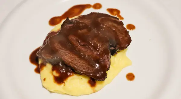 Guancia di vitello tenerissima su un letto di purè, nappata con una ricca salsa bruna.