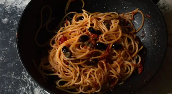 Spaghetti al sugo con olive nere e capperi, un piatto che sa di casa e di sapori intensi, quasi come una pasta con nduja.