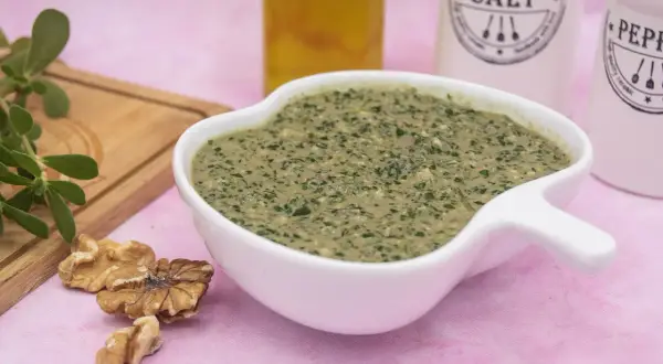 Un cremoso pesto di portulaca, arricchito da noci e olio, pronto per insaporire i tuoi piatti.