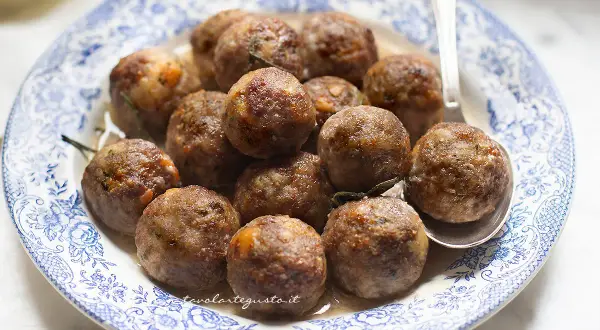 Polpette dorate e succulente in friggitrice ad aria, servite su un piatto di ceramica blu e bianco.