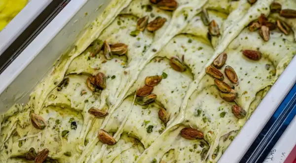 Gelato cremoso al pesto di pistacchio, guarnito con pistacchi interi tostati.