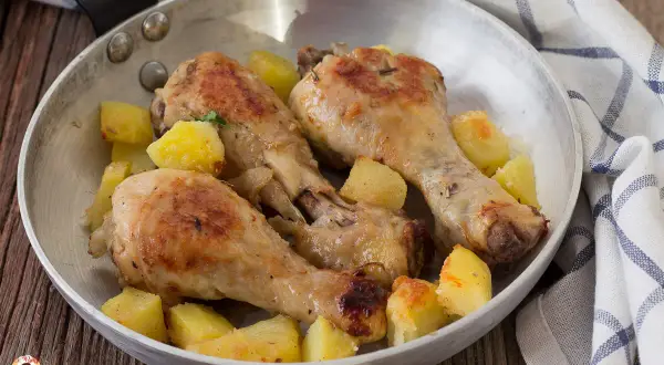 Fusi di pollo in padella, dorati e succulenti, accompagnati da patate croccanti. Un piatto semplice e gustoso.