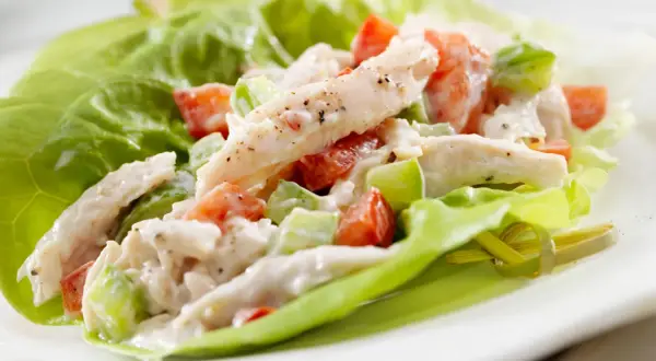 Insalata di pollo con maionese, pomodoro e sedano, servita su foglie di lattuga croccante. Una ricetta fresca e gustosa.
