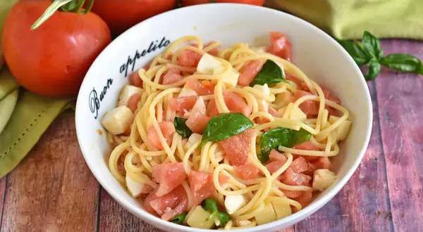 Pasta alla checca con pomodori freschi, mozzarella e basilico, un piatto estivo semplice e gustoso.
