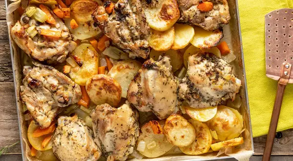 Sovracosce di pollo dorate e succulente, cotte al forno con patate, carote e sedano. Un piatto saporito e invitante.