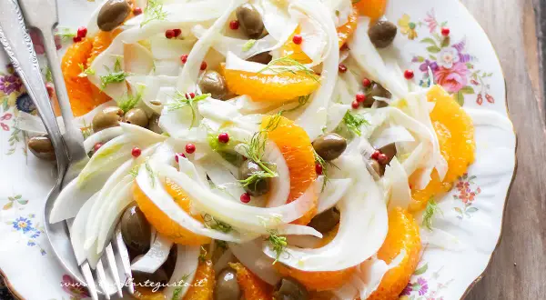 Deliziosa insalata finocchi e arance, con olive verdi e pepe rosa, guarnita con finocchietto fresco. Un piatto fresco e colorato.
