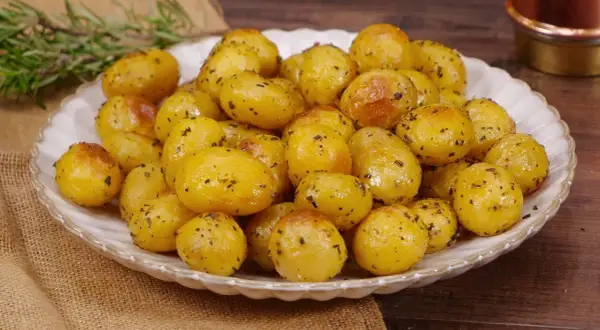 Un piatto invitante di patate novelle al forno, dorate e condite con erbe aromatiche, pronte per essere gustate.