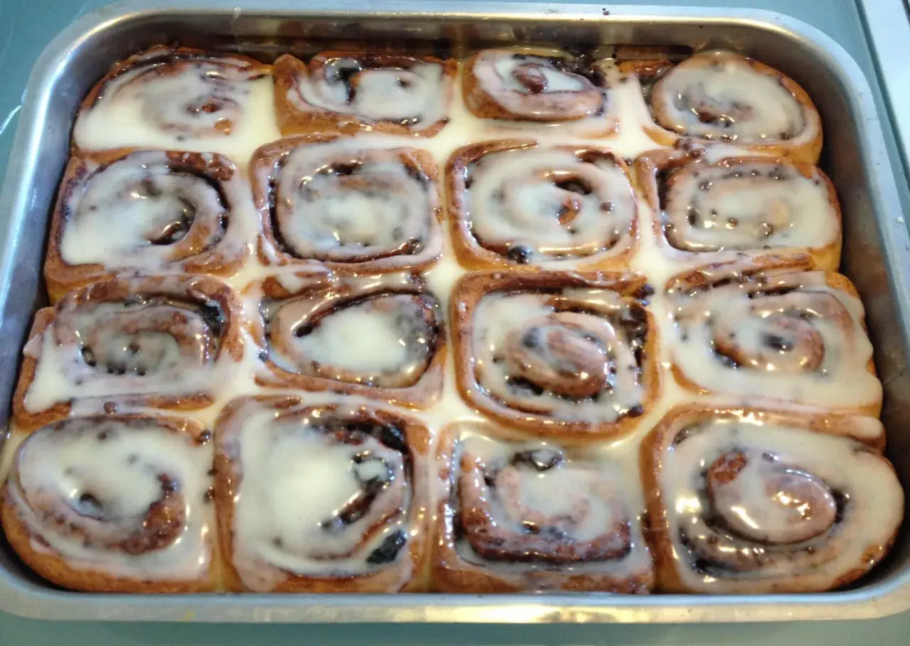 Rotolini alla cannella appena sfornati, ricoperti di glassa bianca e lucida, pronti per essere gustati.