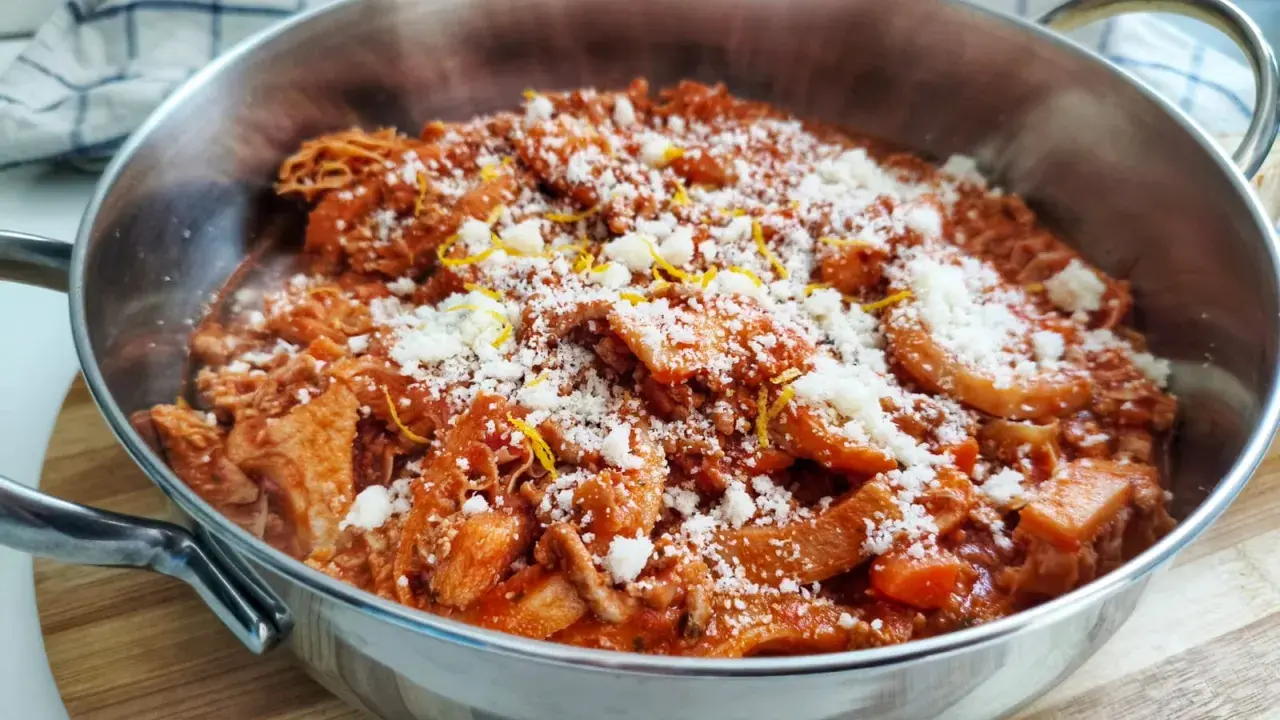 Trippa alla fiorentina fumante in un tegame, cosparsa di parmigiano grattugiato e scorza di limone. Un classico della cucina toscana.
