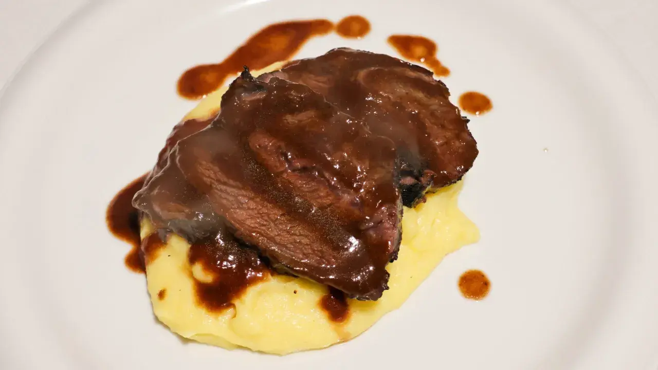Guancia di vitello tenerissima su un letto di purè, nappata con una ricca salsa bruna.