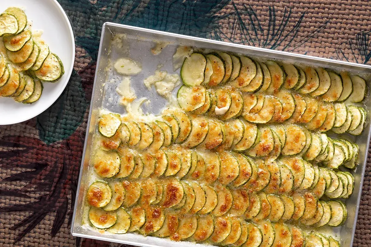 Fette di zucchine gratinate in teglia, un contorno di verdure dorato e invitante, pronto per essere gustato.