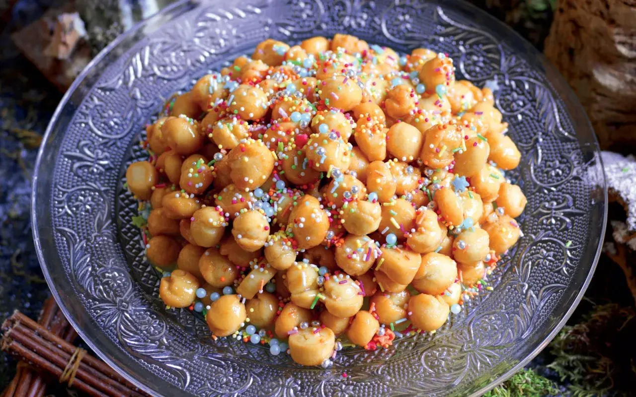 Struffoli ricetta della nonna: palline dorate fritte, ricoperte di miele e confettini colorati, su un piatto decorato.