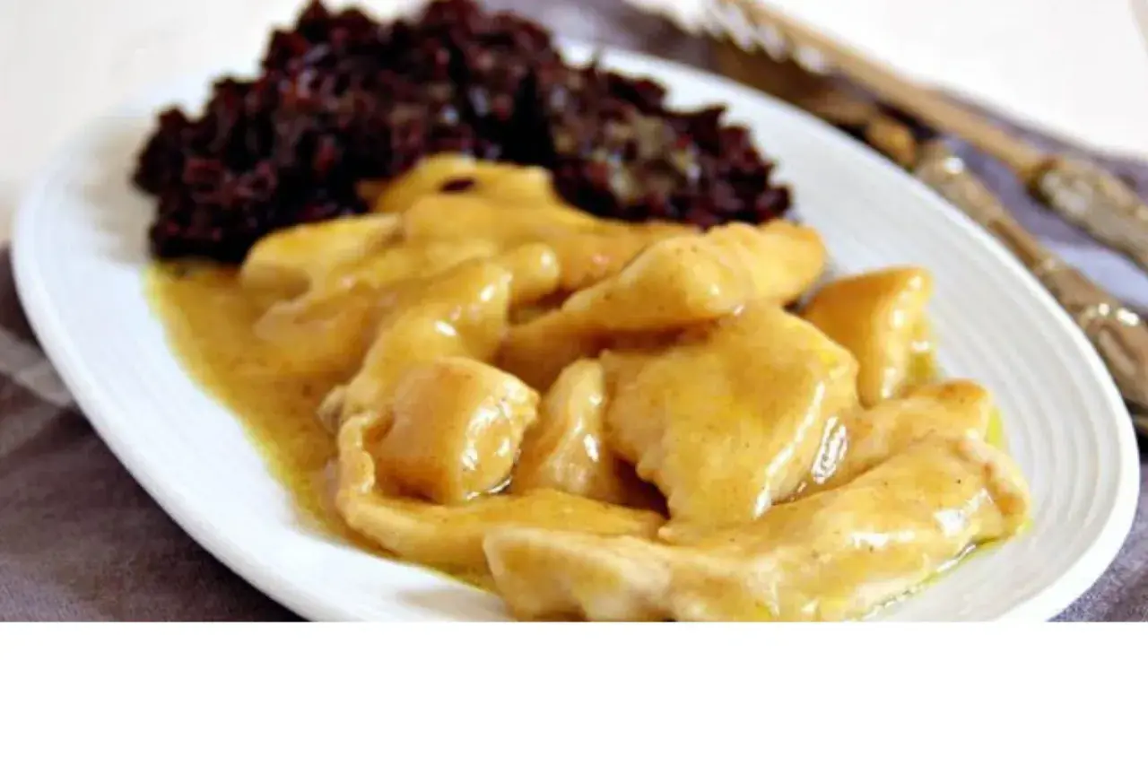 Straccetti di pollo al curry cremosi, serviti con riso nero. Un piatto saporito e invitante.