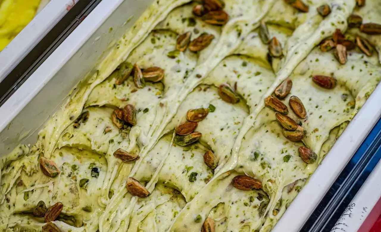 Gelato cremoso al pesto di pistacchio, guarnito con pistacchi interi tostati.