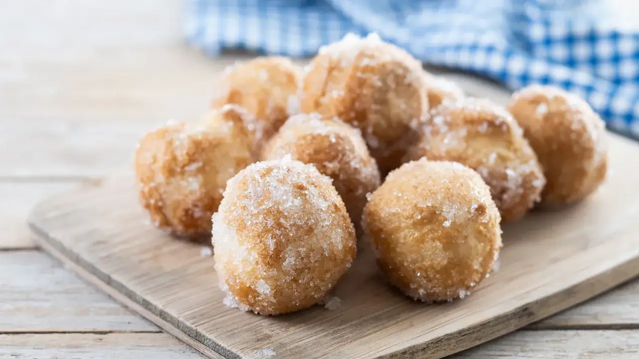 Frittelle di Carnevale facili e veloci, dorate e cosparse di zucchero, pronte per essere gustate.