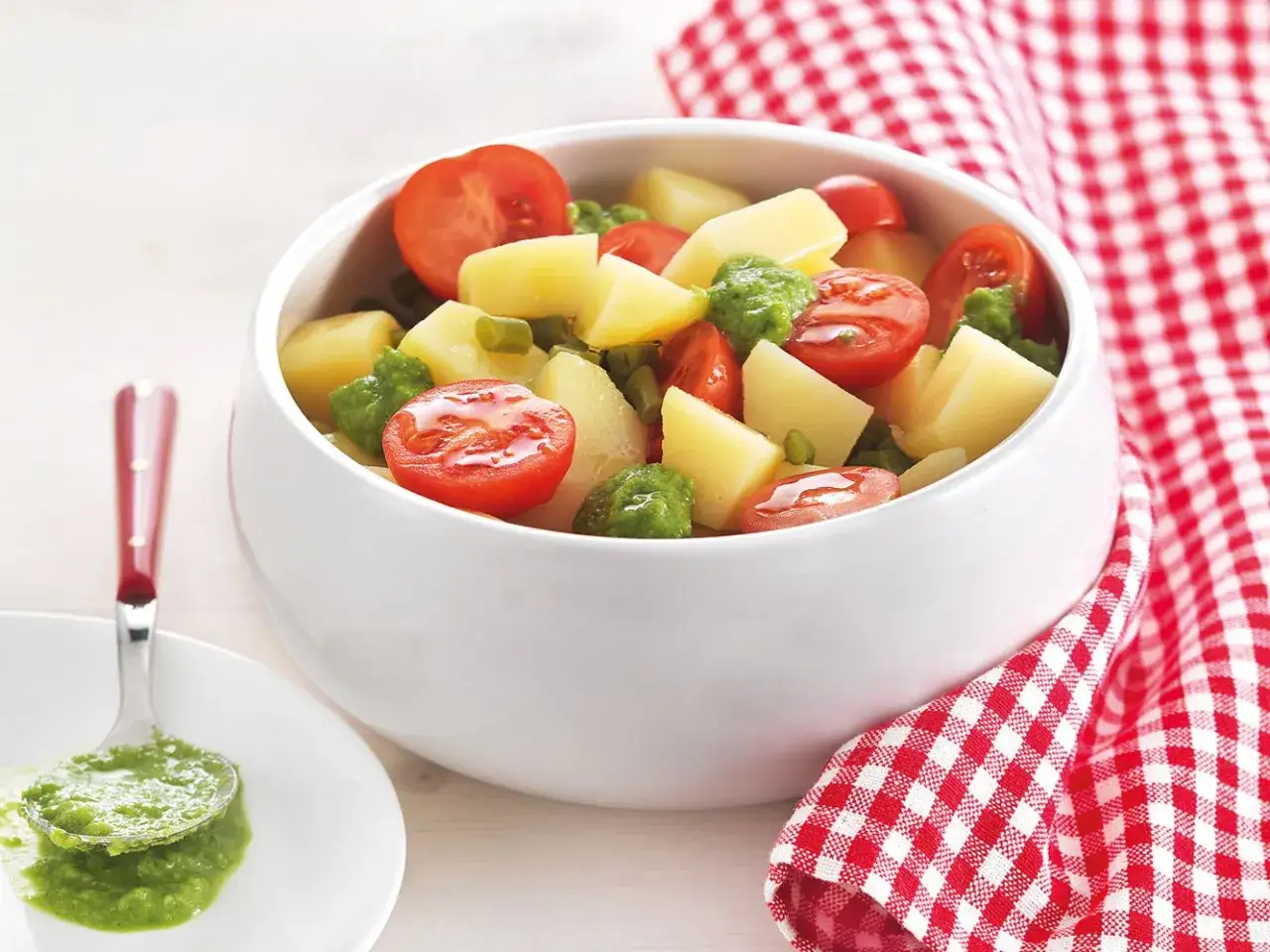 Insalata di patate estiva con pomodorini e piselli, condita con una salsa verde brillante. Perfetta per un pranzo leggero.