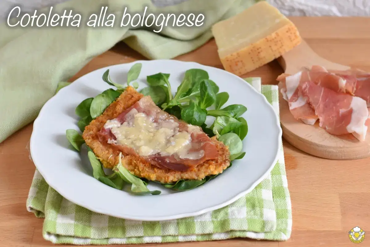 Cotoletta alla bolognese dorata e croccante, guarnita con prosciutto e formaggio fuso, servita su un letto di insalata fresca.