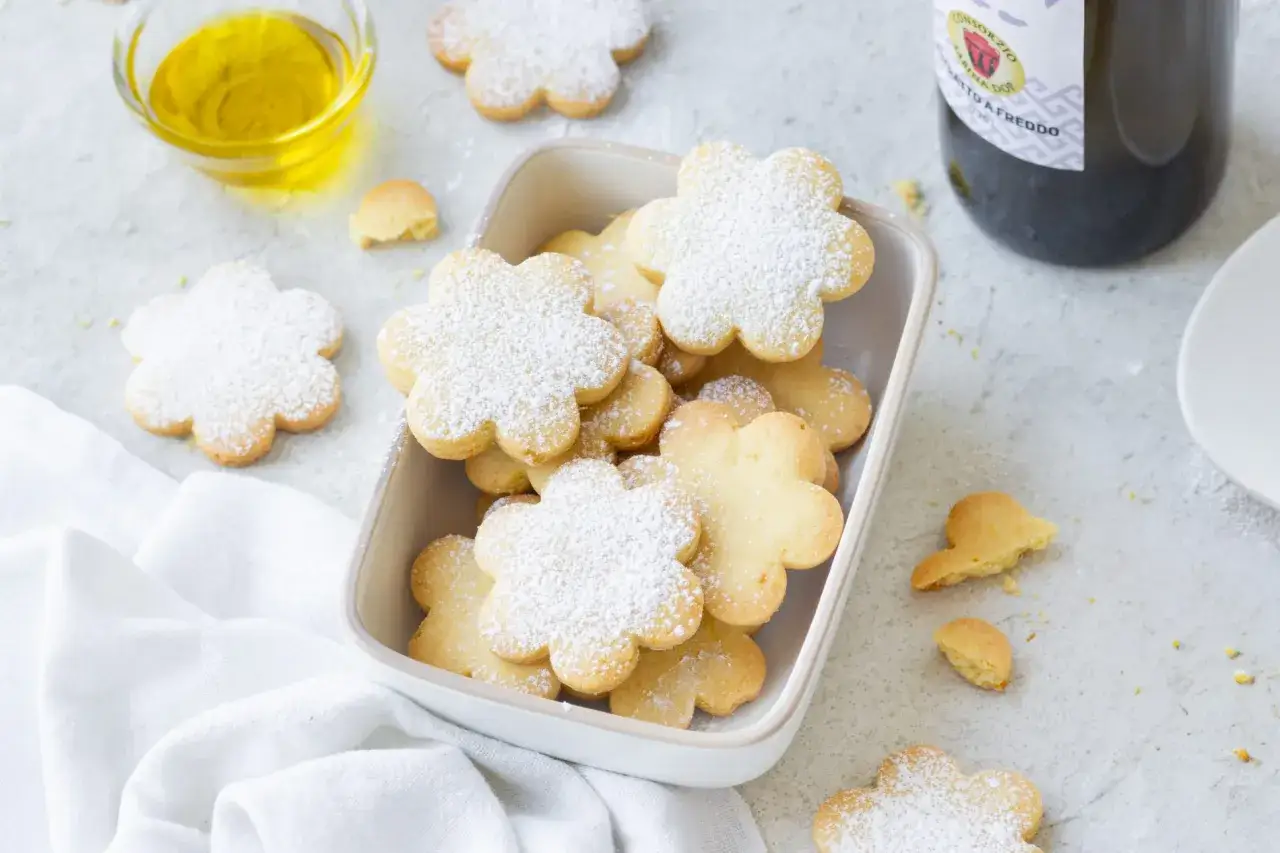 Deliziosi biscotti senza lattosio a forma di fiore, spolverati di zucchero a velo, pronti per essere gustati.
